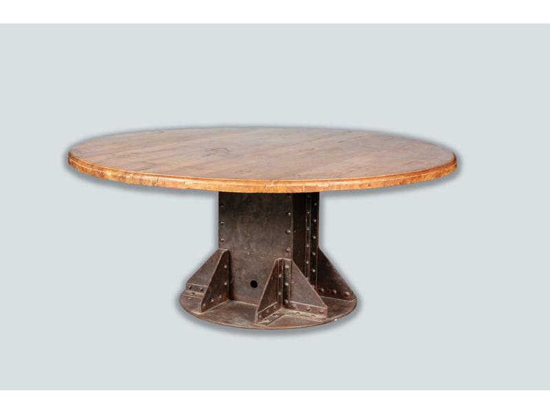 Grande table ronde, plateau en bois naturel reposant sur un socle central en fer riveté.  Hauteur : 77 cm.  Diam.: 180 cm.