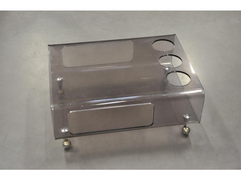 Table basse en plexiglass thermoformé reposant sur quatre roues.  Dim.: 27x60x46 cm.