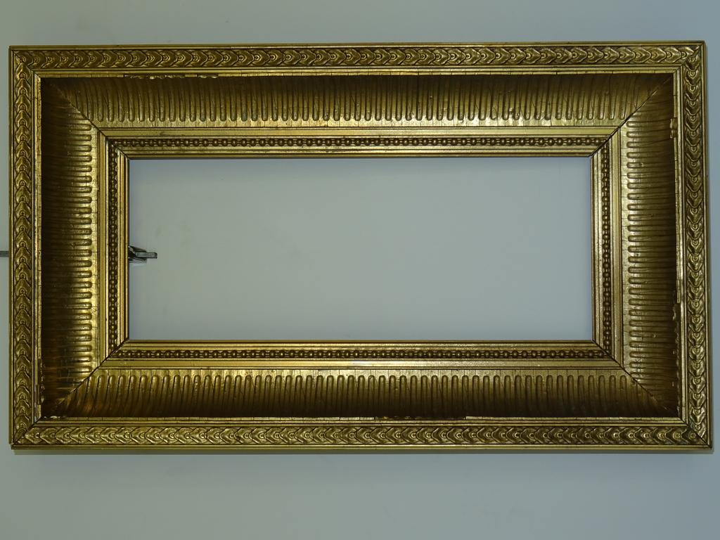 Petit cadre en bois et stuc doré à motif de canaux, frises de pilastres et perles. Style XIX°, moderne. Dim extérieure: 27,5x47,5cm. Dim intérieure: 15x35cm (quelques sauts de stuc).