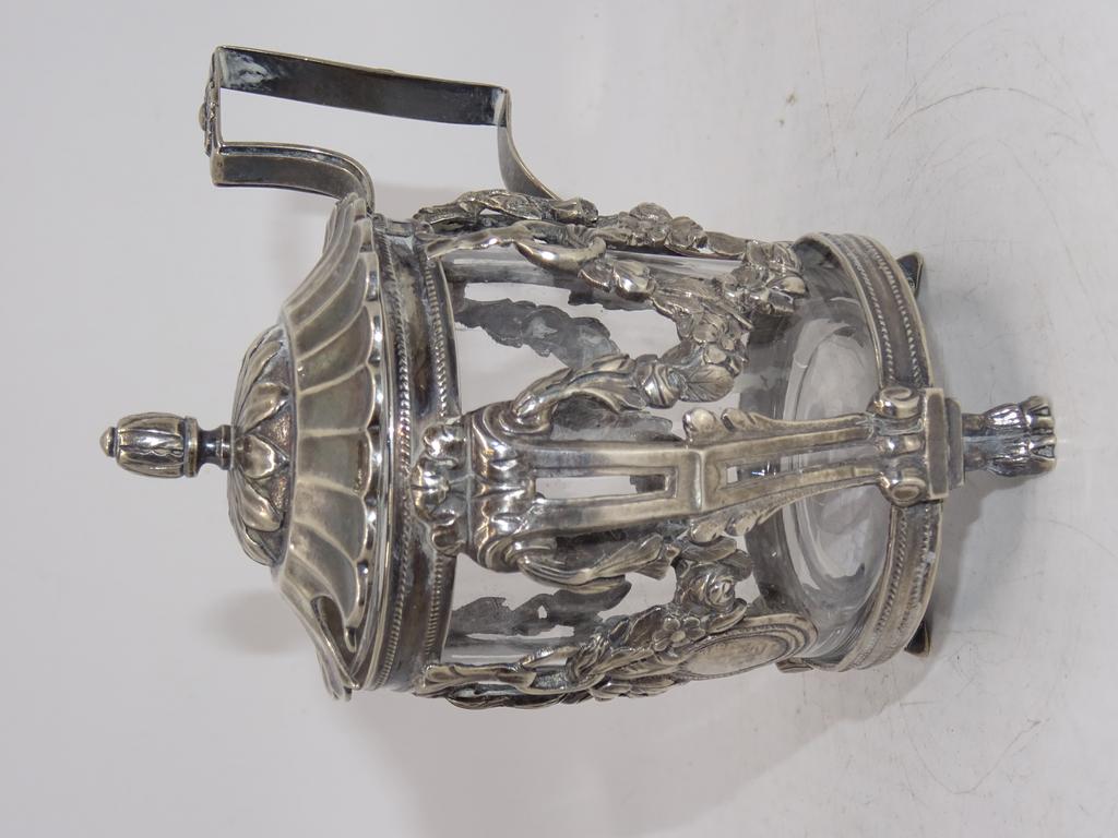Moutardier en argent d'époque Louis XVI à décor de guirlandes de fleurs. Poinçons aux fermiers Généraux (bague supérieure coupée). Intérieur en verre transparent. Poids net: 149g. Hauteur: 11cm.