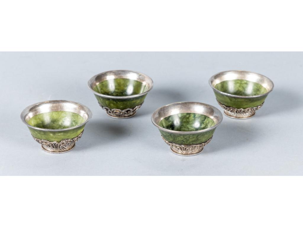 Quatre petits bols en jade sur une monture en argent bas titre étranger (à charge). Diamètre: 7,5cm.