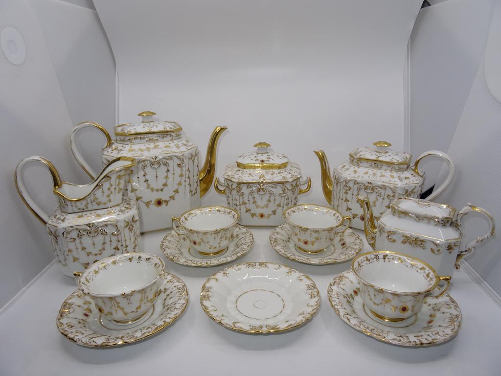 Paris : Service à thé en porcelaine à décor de pampres et rinceaux dorés comprenant une théière, une cafetière, un sucrier, un pot à lait et quatre sous-tasses. Epoque Restauration.