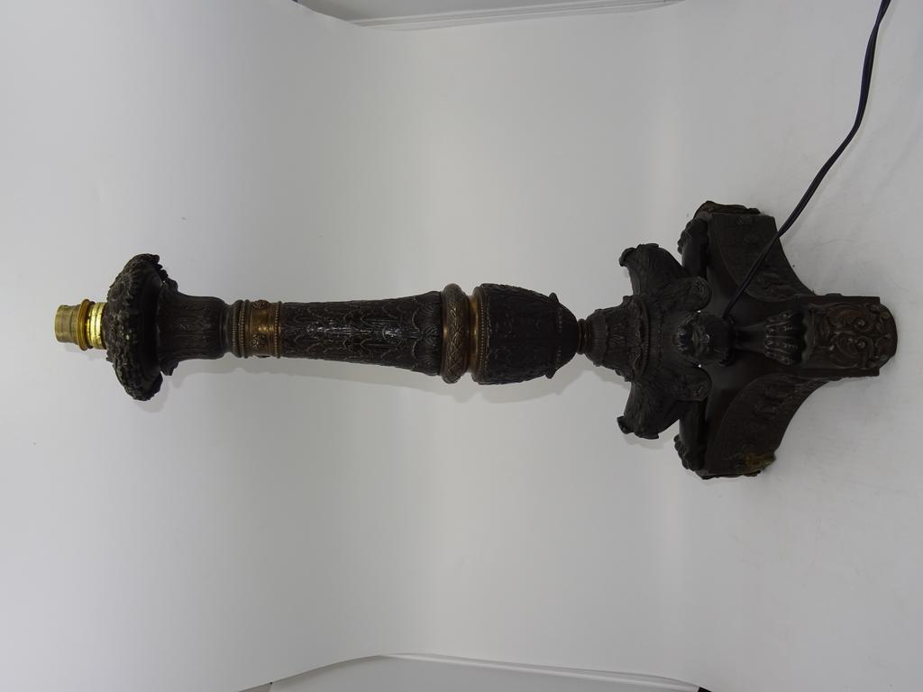 Lampe en métal repoussé de style Restauration sur griffes de lion. Hauteur: 48cm.