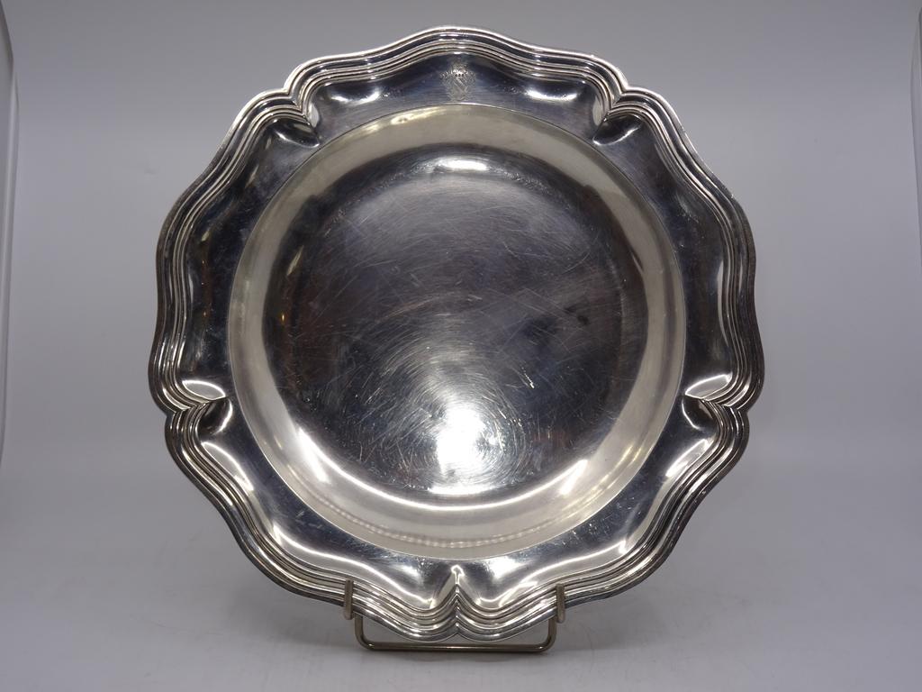 Plat creux en argent à contours et agrafes à décor armorié. Poinçon Minerve. Poids : 705 gr.