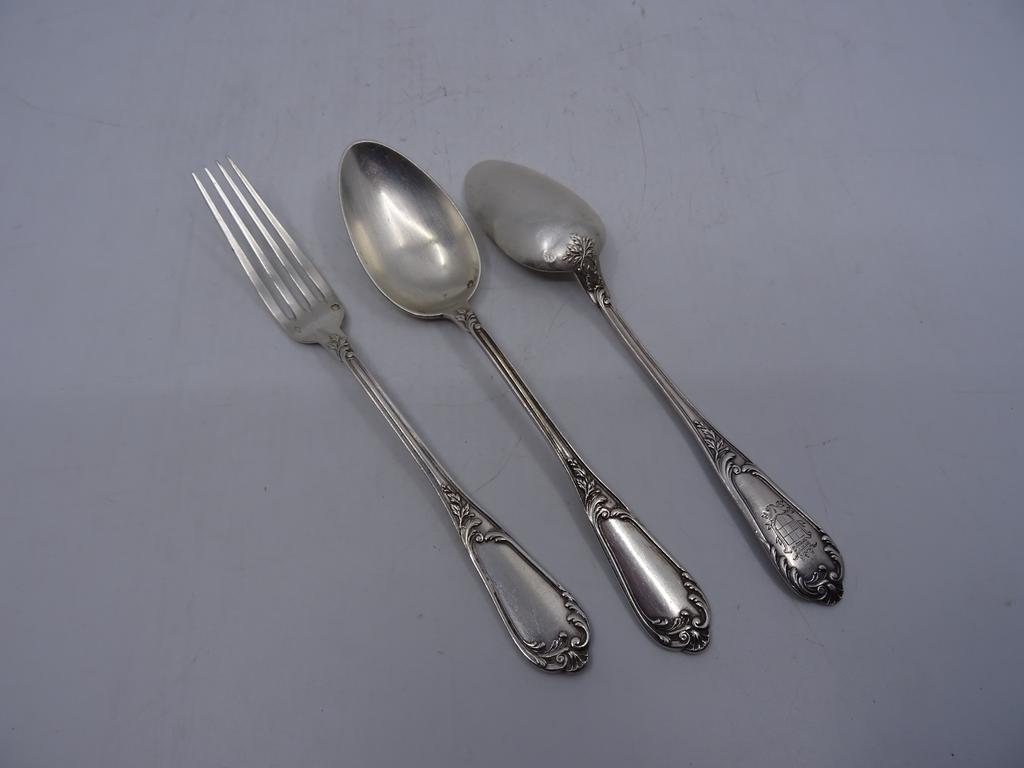 Seize couverts à entremet en argent et neuf cuillères à entremet en argent à décor de rinceaux fleuris. Poinçon Minerve. Poids total : 1931 gr.