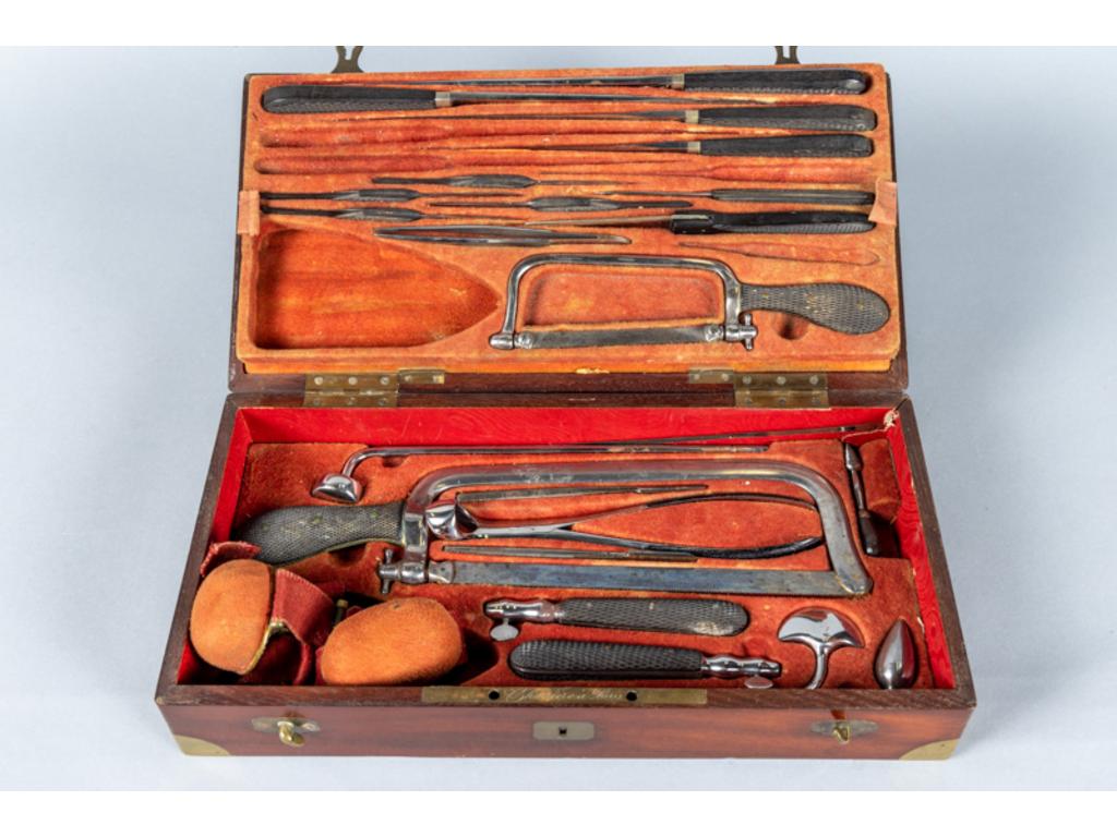 CHARRIERE à Paris: Coffret de chirurgie, fermant à clef (manquante) et deux crochets. Plaqué d'acajou renforcé de coins en laiton, garni de peau teinté rouge, à platine signée 