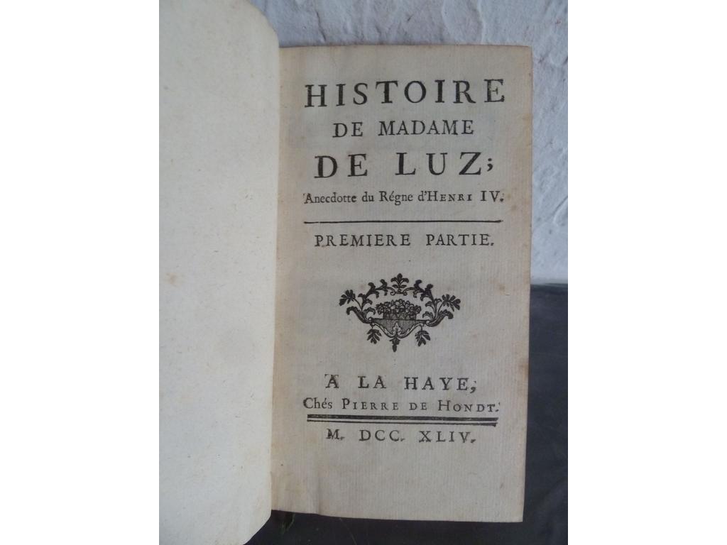 [DUCLOS, Charles Pinot, Sieur de] : Histoire de Madame Luz , anecdote du Règne dHenri IV. La Haye : Pierre de Hondt, 1744. 2 parties en 1 volume in-12°. Reliure de lépoque plein veau fauve, dos à nerfs orné de caissons de double filet doré fleuronnés, pièce de titre en maroquin rouge, filet doré sur coupes, toutes tranches rouges. TRES BEL EXEMPLAIRE, fort bien conservé. Madame de Luz fût l'une des plus belles femmes du royaume d'Henri IV, vertueuse et fidèle à son mari. Mais, le baron de Luz est impliqué dans un complot qui vise à renverser Henri IV. Arrêté, il est menacé de la peine de mort. Convaincue de son innocence et décidée à le libérer, qui à perdre sa vertu. A travers ce portrait de femme à l'innocence souveraine, Duclos dénonce l'hypocrisie d'une société pudibonde. Madame de Luz est une sorte de Princesse de Clèves libertine.
