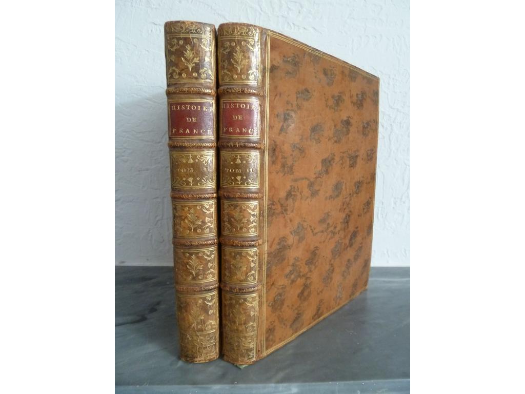 HENAULT : Nouvel abrégé chronologique de lhistoire de France, contenant l. es évènements de notre histoire depuis Clovis jusquà la mort de Louis XIV. Paris :  Prault, 1768. 2 volumes in-4°. Reliures de lépoque plein veau havane, dos à nerfs ornés de caissons de double filet doré fleuronnés, pièces de titre en maroquin rouge et tomaisons dorées, triple filet doré en encadrement des plats, double filet doré sur coupes, toutes tranches rouges. Illustré dune vignette sur titre répétée, dun superbe portrait de la Reine Marie Leckzinska daprès Nattier en en-tête, 3 en-têtes de Cochin gravé par Moreau, 3 lettrines ornées par Chetel  et 30 culs-de-lampe par Moreau et 1 grand cul-de-lampe à pleine page in fine. TRES BEL EXEMPLAIRE, fort bien conservé pour cet ouvrage qui connaîtra dés sa 1ère édition en 1744, un immense succès et le livre est traduit dans de très nombreuses langues, y compris en chinois. Voltaire dit du président Hénault qu'il est le seul homme qui ait appris aux Français leur histoire. L'ouvrage vaut à l'auteur d'être élu en 1755 comme membre honoraire de l'Académie des inscriptions et belles-lettres.?