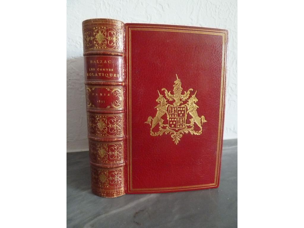 BALZAC, Honoré de. (DORE, Gustave) : Les contes drolatiques. Paris : Bureaux de la Société générale de Librairie, 1855. Un volume fort in-8°. Reliure plein maroquin rouge, dos à nerfs orné de caissons de double filet doré décorés de volutes, fleurons et maques de théâtre dorés au centre, triple filet en encadrement des plats avec au centre grandes armes dorées de la famille de VIEFVILLE DES ESSARTS, double filet doré sur coupes, roulettes, dents de rats et filets dorés sur chasses, toutes tranches dorées. Reliure signée par PETIT. Etui bordé assorti. 1ère édition abondamment illustrée par Gustave DORE avec ses célèbres et remarquables 425 gravures sur bois, in-texte et à pleine page. (Brivois : 32 : « Si de tous les ouvrages illustrés par Gustave doré, il ne devrait en rester qu'un, ce serait celui-là : l'illustration est à la hauteur du texte, et ce n'est pas peu dire, puisque Balzac considérait les Contes drolatiques comme son chef-d'uvre ». Ex-libris doré sur pièce de maroquin rouge de Georges DEGRYSSE et ex-libris armorié imprimé du Président de VIEFVILLE DES ESSARTS. Légers frottis, rares rousseurs sinon TRES BEL EXEMPLAIRE, en reliure signée aux armes.