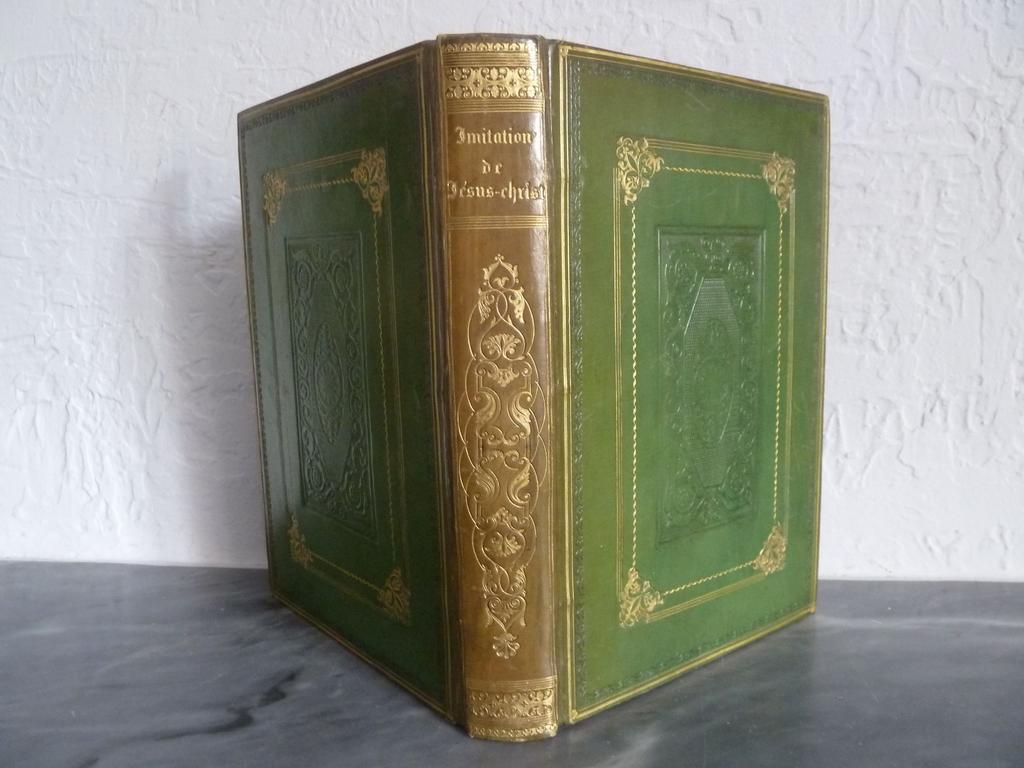 DASSANCE, Abbé. (JOHANNOT, Tony et CAVELIER) : Limitation de Jésus-Christ, illustrée par MM. Tony Johannot et Cavelier. Paris : Curmer, 1836. 1 volume grand in-8°. Reliure de lépoque plein veau vert, dos lisse richement orné de fleurons romantiques dorés, double encadrement de filets et roulettes dorés et à froid des plats avec composition romantique à froid au centre, roulettes dorées sur coupes et chasses, toutes tranches dorées. Bien complet du titre-frontispice en chromolithographie et des 10 gravures hors-texte sur acier de Tony JOHANNOT et CAVELIER. Dos éclairci sinon BEL EXEMPLAIRE en reliure romantique, exempt de rousseurs.