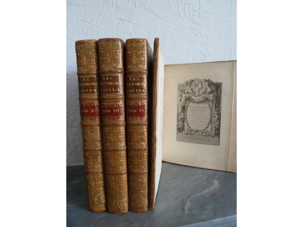 OVIDE. (BOUCHER, EISEN, GRAVELOT, MOREAU, etc.) : Les métamorphoses en latin et en français, de la traduction de labbée Banier. Paris : Basan   Le Mire (Delormel puis Delalain/ de limprimerie de Prault), 1767-1771. 4 volumes in-4°. Reliures de lépoque plein veau blond, dos à nerfs ornés de caissons de double filet doré fleuronnés, pièces de titre et de tomaison en maroquin grenat, triple filet doré en encadrement des plats, double filet doré sur coupes, roulette dorée intérieure, et toutes tranches dorées. Magnifiquement illustré dun frontispice, de 3 pages gravées de dédicace, 4 fleurons sur titre, 30 en-têtes, 1 magnifique cul-de-lampe à la fin du 4ième volume à pleine page et 139 hors-texte dans de beaux encadrements daprès les plus fameux artistes de lépoque : BOUCHER, EISEN, GRAVELOT, LEPRINCE, MONNET, MOREAU, PARIZEAU, et SAINT-GOIS. Les graveurs travaillant pour le Mire sont : Bacquoy, Basan, Binet, Duclos, de Gendt, Helman, De Launay etc. (Cohen : 769). Quelques rousseurs au tome 1 plus particulièrement, quelques usures et fendillements quelques parfaites restaurations aux coiffes notamment sinon BEL EXEMPLAIRE, dun des livres du XVIIIe siècle le plus galamment illustré selon Cohen, qui contribua le plus fortement à répandre le goût français dans toute lEurope du XVIIIe siècle.