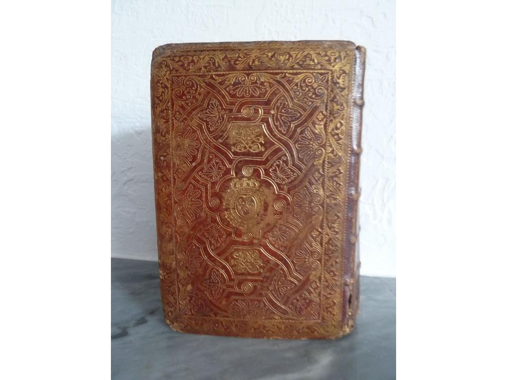 Office de la semaine sainte à lusage de Rome et de Paris, en latin et en français  Paris : Collombat, 1732. Un volume in-8°. Reliure de lépoque plein maroquin rouge, dos à nerfs orné de caissons de double filet doré fleuronnés et fleurdelysés au centre, plats richement orné de riches compartiments dorés à la fanfare composés dentrelacs de quadruples filets dorés ornés de feuillages, rinceaux et fleurons frappés au pointillé, petite dentelle dorée en encadrement, armes et chiffres dorés au centre du Roi Louis XV (OHR : Planche 2495 fer 9 pour les armes et fer 31 pour le chiffre), roulettes dorées chasses, toutes tranches dorées. Illustré dun frontispice et dun titre gravés, de 4 hors-texte daprès Humblot gravés par SCOTIN. Exemplaire réglé en rouge. Coiffes arasées, diverses usures, des pages brunies, rousseurs éparses.