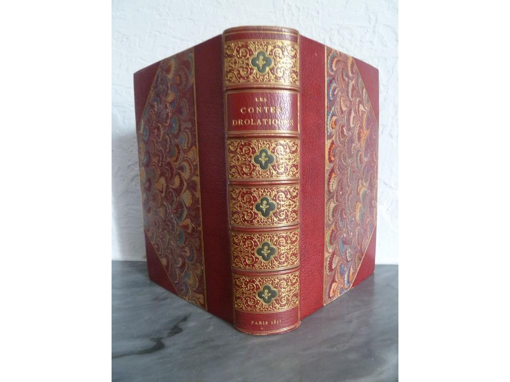 BALZAC, Honoré de. (DORE, Gustave) : Les contes drolatiques. Paris : Bureaux de la Société générale de Librairie, 1855. Un volume fort in-8°. Reliure demi-maroquin rouge à coins, dos à nerfs très richement orné de filets courbes, rinceaux et points dorés avec fleurons quadrilobés mosaïqués en maroquin vert orné dune fleurette dorée au centre, double filet doré sur plats, tête dorée. Reliure signée par CLAESSENS. 1ère édition abondamment illustrée par Gustave DORE avec ses célèbres et remarquables 425 gravures sur bois, in-texte et à pleine page. (Brivois : 32, cf. supra). Quelques légers frottis, rousseurs passim. BON EXEMPALIRE, bien établi.