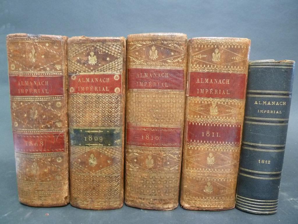 (Almanach) ALMANACH IMPERIAL pour 1808, 1809, 1810, 1811. Paris : Testu, s.d. 4 volumes grand et fort in-8°. Reliures de lépoque plein veau fauve, dos lisses richement ornés de filets, croisillons, étoiles et aigles impériales, roulettes dorées en encadrement des plats, sur coupes et sur chasses (variantes dans les décors), pièces de titre et de tomaison en maroquin, toutes tranches dorées. Frottis et autres menus défauts. ON Y JOINT LAlmanach impérial pour 1812. Petit in-8°. Reliure postérieure demi-chagrin. Ex. déboité, ex. de travail. BON ENSEMBLE (n.c.)