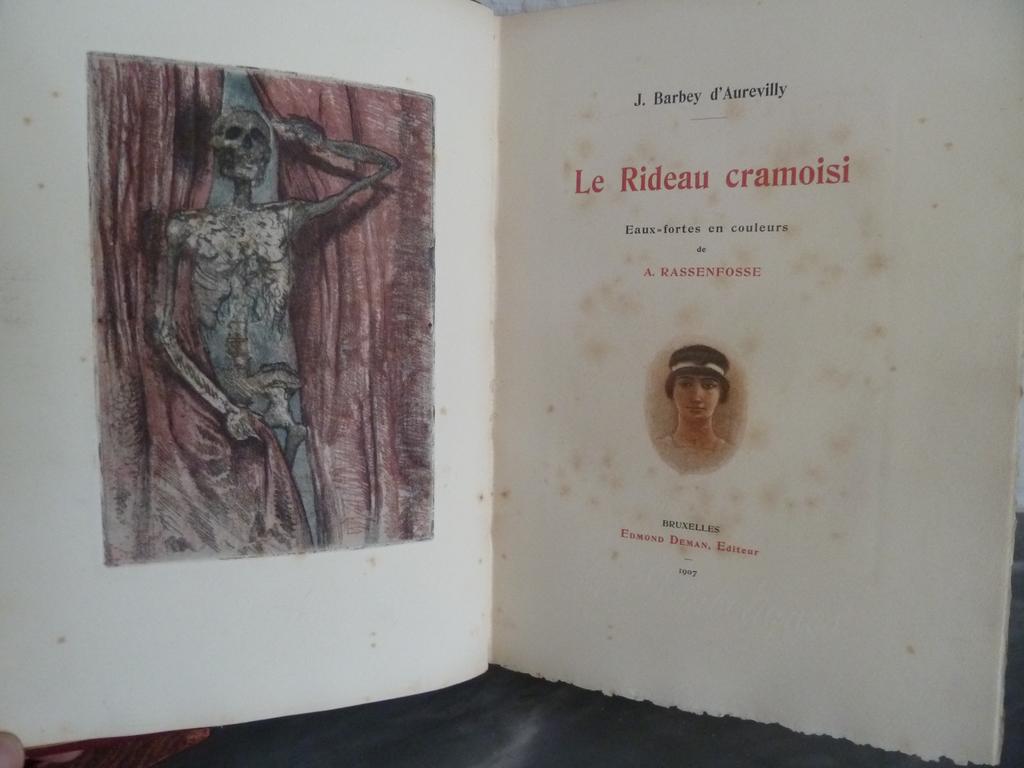 BARBEY DAUREVILLY, Jules. (RASSENFOSSE, Armand) : Le rideau cramoisi. Bruxelles : Edmond Deman, 1907. 1 volume in-4°. Reliure de lépoque plein maroquin grenat, dos à nerfs ornés de caissons dune succession de filets à froid, listel de maroquin noir mosaïqué bordé de filets à froid en encadrement des plats, large cadre intérieure orné de 6 filets dorés, doublures et gardes de moire rouge, toutes tranches dorées. Couvertures et dos conservés. Etui bordé assorti. Reliure signée par CANAPE.  Illustré de 16 eaux-fortes en couleurs dArmand RASSENFOSSE dont vignette sur couverture, frontispice, vignette sur titre, 2 en-têtes, 11 hors-texte. Tiré à 125 ex. numérotés sur Rives. 1 de ceux-ci. Usures avec manques aux dos et mors principalement, rousseurs.